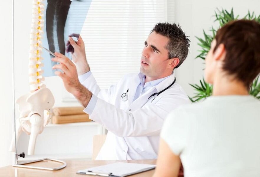 the doctor examines the x-ray to diagnose thoracic osteochondrosis